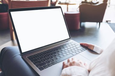Kafede otururken boş beyaz masaüstü ekran kullanan ve yazan kadınların ellerinin görüntüsü.