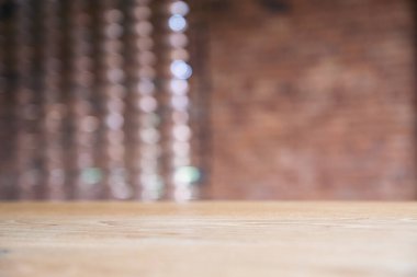 Bulanık tuğla duvar arkaplanı olan eski ahşap masanın yakın plan görüntüsü