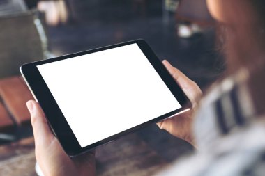 Beyaz ekranlı siyah tablet tableti tutan ve kullanan bir kadının görüntüsü 