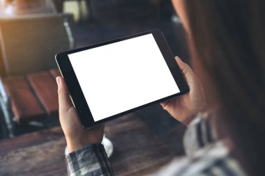 Kafe 'de elinde boş beyaz masaüstü ekranı olan siyah tablet bir kadının görüntüsü