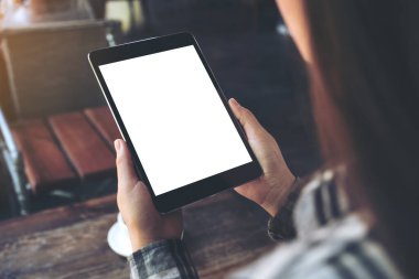 Kafe 'de elinde boş beyaz masaüstü ekranı olan siyah tablet bir kadının görüntüsü