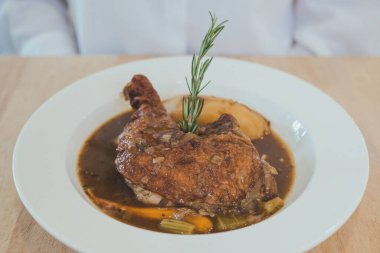 Ahşap masadaki yavaş pişirilmiş chipotle tavuk yahnisinin yakın plan görüntüsü.