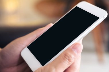 Boş siyah masaüstü ekranlı beyaz cep telefonu tutan ellerin görüntüsü 
