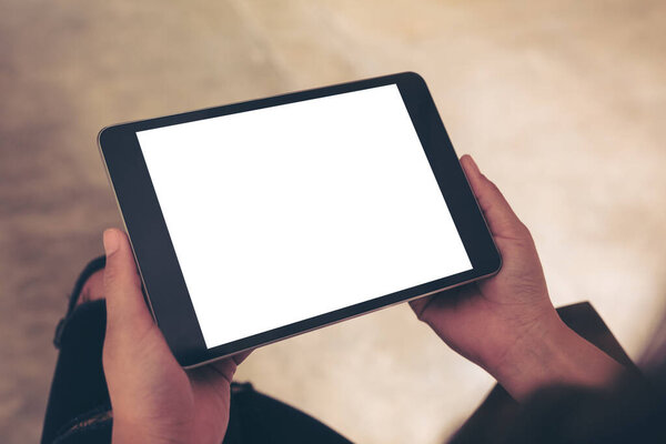 Mockup image of woman holding black tablet pc with blank white desktop screen 