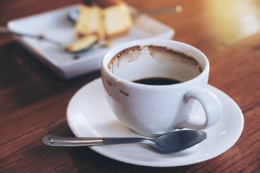 Kafedeki masada bir fincan kahve ve bir parça kek.