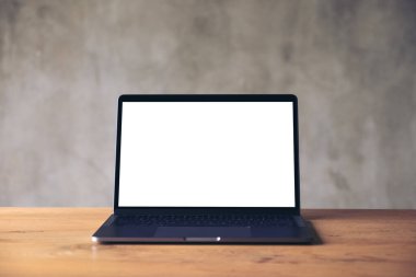 Boş beyaz masaüstü ekranlı dizüstü bilgisayarın beton duvar arkaplanlı görüntüsü