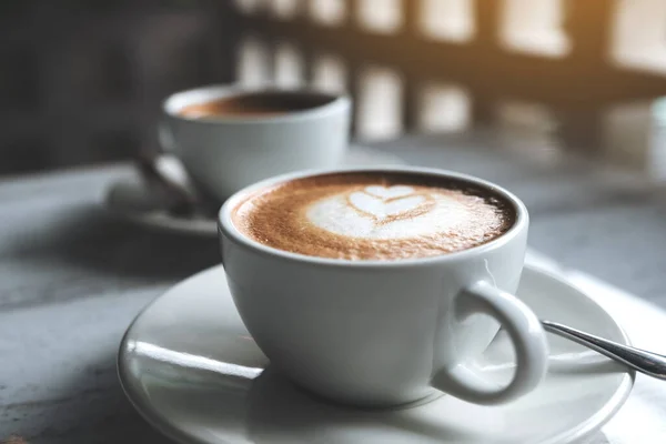 カフェのテーブルの上のホットコーヒーの2つの白いカップのクローズアップイメージ — ストック写真