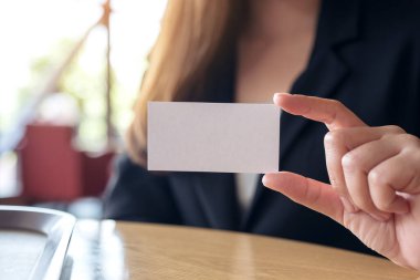 Elinde boş bir kartvizit tutan bir iş kadını. 