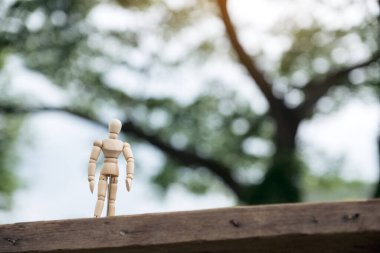 Ahşap figürün yakın plan resmi. Arka planı bulanık, ahşap bir masada duran bir adamın.