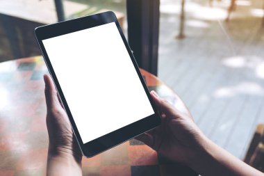 Siyah tableti beyaz ekranla tutan ellerin görüntüsü