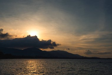 Deniz ya da okyanus manzarası ve akşam vakti çok güzel bir geçmişi olan dağ.