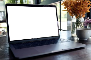 Eski kafedeki ahşap masada boş beyaz masaüstü ekranlı dizüstü bilgisayarın görüntüsü