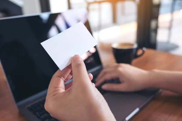 Una Mano Sosteniendo Tarjeta Visita Vacía Blanca Mientras Utiliza Ordenador —  Fotos de Stock