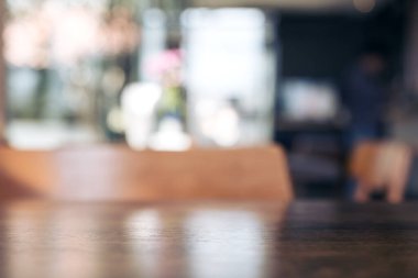 Ahşap masanın bulanık görüntüsü ve modern kafenin arka planında sandalyeler.