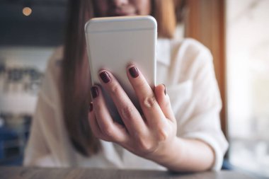 Modern kafede güzel bir Asyalı kadının elinde tuttuğu, kullandığı ve baktığı yakın plan görüntüler.