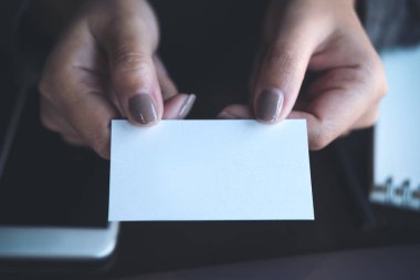 Ofisteki birine boş kartvizit veren bir iş kadını.