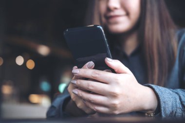 Modern kafede güzel bir Asyalı kadının elinde tuttuğu, kullandığı ve baktığı yakın plan görüntüler.