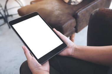 Boş beyaz masaüstü ekranlı siyah tableti tutan ellerin görüntüsü 