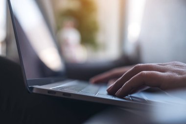 Masadaki dizüstü bilgisayarın klavyesinde çalışan ve yazan ellerin yakın plan resmi