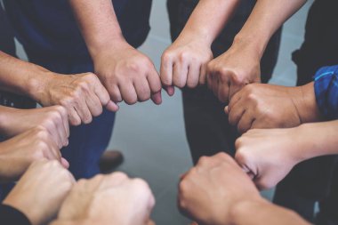 Pek çok insanın yapbozu daire içinde tutan ellerinin yakın plan görüntüsü.