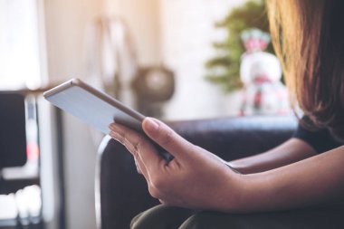 Kafedeki tablet bilgisayar kullanan ve el ele tutuşan kadınların yakın plan görüntüsü.