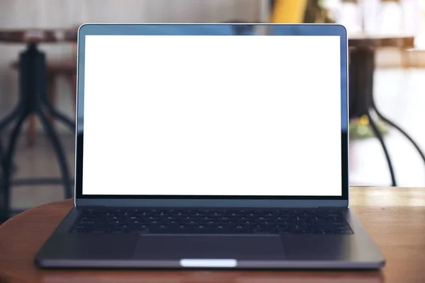 現代のカフェで木製のテーブルの上に空白の白いデスクトップ画面とラップトップのモックアップイメージ — ストック写真