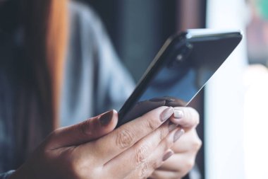 Modern kafede el ele tutuşmanın ve akıllı telefon kullanmanın yakın plan görüntüsü