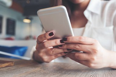 Modern kafede güzel bir Asyalı kadının elinde tuttuğu, kullandığı ve baktığı yakın plan görüntüler.