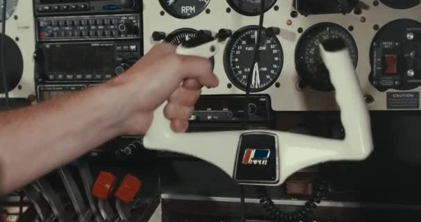 Prise de vue détaillée d'un petit avion de passagers dans le hangar, détails rapprochés, panorama du surf, mains tenant le volant, tableau de bord, hélice en acier, châssis, jauges — Video