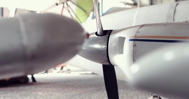 Detailaufnahme eines kleinen Passagierflugzeugs im Hangar, Nahaufnahmen, Surfpanorama, Hände halten das Lenkrad, Armaturenbrett, Stahlpropeller, Fahrgestell, Messinstrumente — Stockvideo