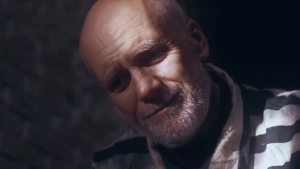 Anciano Sienta Una Sombría Celda Prisión Está Vestido Con Uniforme — Vídeo de stock