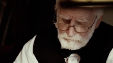 Eski bir şarkıcı çalışır onun yaratıcı stüdyo, şık retro giysiler dokulu bir yazar, bir gri saçlı sakallı adam, bir not defteri yapraklar, şiirler ve daktilo üzerine bir kitap yazıyor