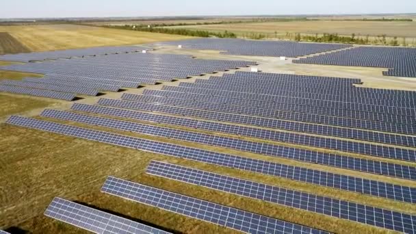 Prise de vue aérienne de panneaux solaires dans un grand champ ouvert, drone survolant des panneaux solaires, technologie moderne d'énergie verte, énergie de la vallée de silicium, le soleil réfléchi dans les miroirs d'énergie — Video