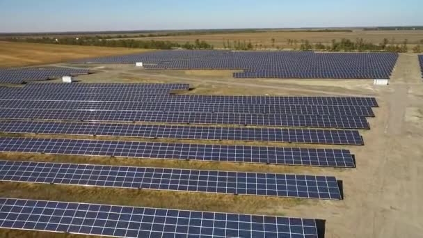 Prise de vue aérienne de panneaux solaires dans un grand champ ouvert, drone survolant des panneaux solaires, technologie moderne d'énergie verte, énergie de la vallée de silicium, le soleil réfléchi dans les miroirs d'énergie — Video