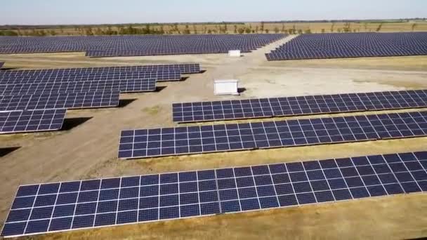 Prise de vue aérienne de panneaux solaires dans un grand champ ouvert, drone survolant des panneaux solaires, technologie moderne d'énergie verte, énergie de la vallée de silicium, le soleil réfléchi dans les miroirs d'énergie — Video