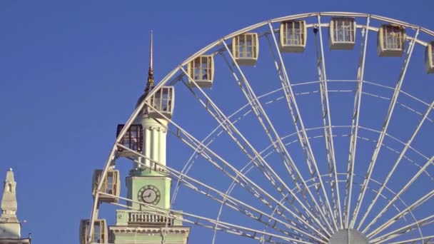 People ride the Ferris Wheel on the background of the old church — Stock Video