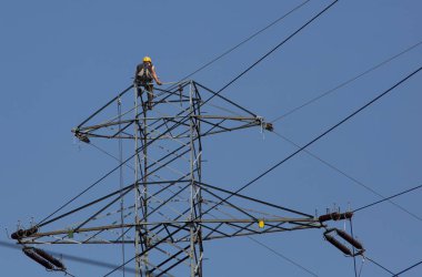 Elektrikçi tırmanmaya yüksek, elektrik direği üzerinde çalışmaya. Elektrikçi tamir sistemi elektrikli tel.