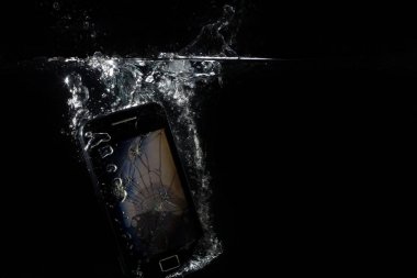 Telefonu suya batırılır. Suya atılmış kırık smartphone. 