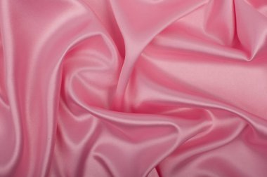 Arka plan olarak pembe saten kumaş. Soyut lüks bez ya da sıvı dalga.
