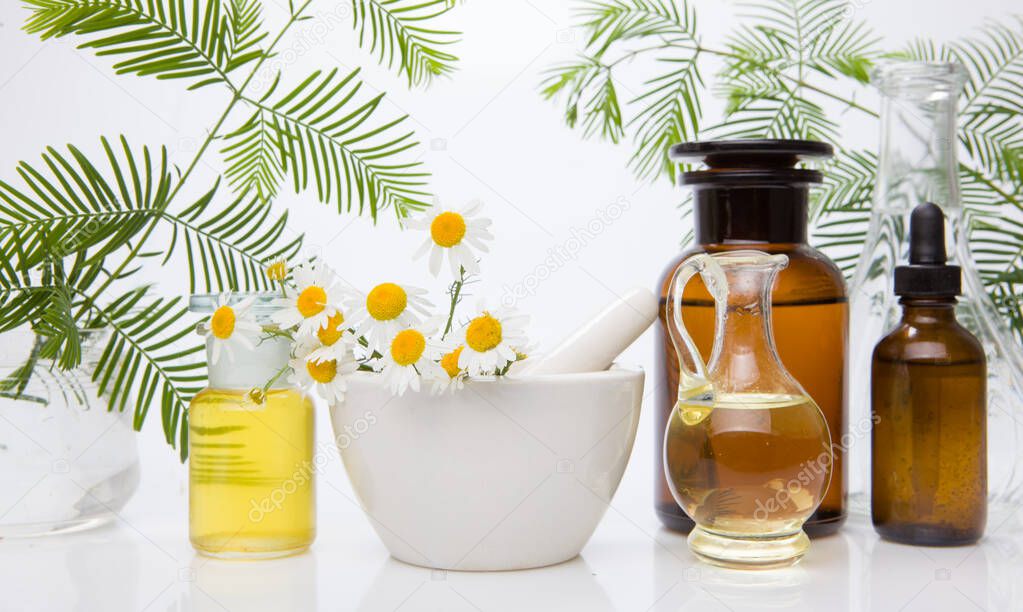 Oil for skin care, massage from natural ingredients, herbs in glass jars.