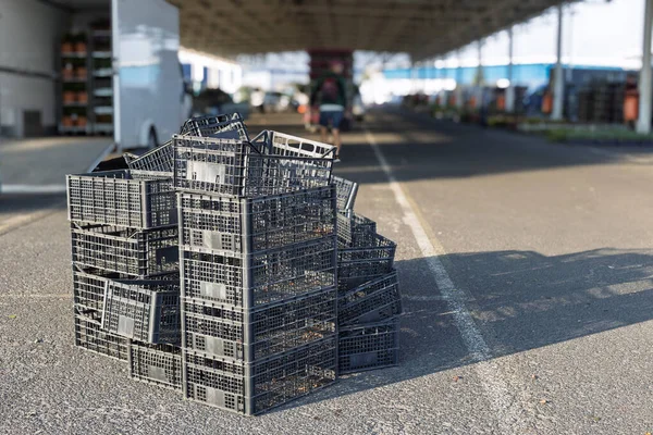 Stack of empty black plastic crates at market