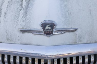 Wroclaw, Poland - August 28 2025: Close up of rusted GAZ Volga emblem on Soviet car hood