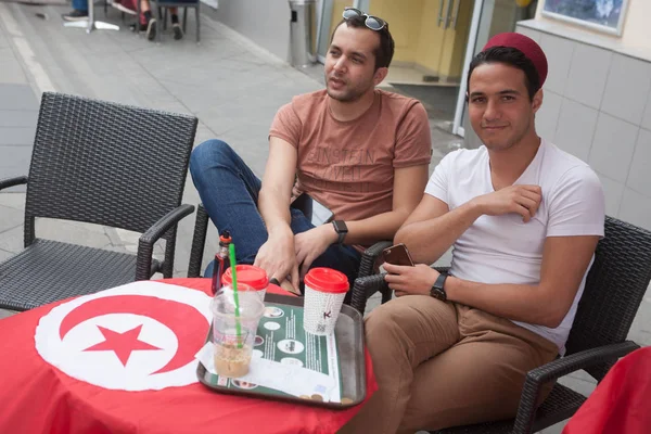 Moscow, Rusya Federasyonu - 21 Haziran 2018: Tunus futbol taraftarları Dünya Kupası 2018 sırasında Nikolskaya sokakta yemek yiyorlar. Nikolskaya Street Moskova merkezinde yer almaktadır.