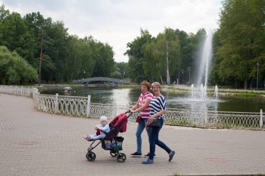 Moskova, Rusya - 18 Temmuz 2018: Lianozovo Park Su birikintisi yakın yürüyüş bebek arabası ile iki kadın. Bu parkın kuzey doğu Moskova'da bulunan.
