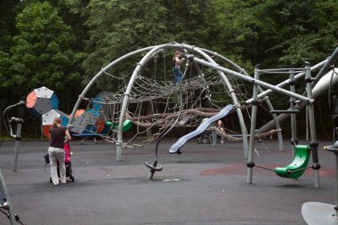 MOSCOW, RUSSIA - JULY 18, 2018: Children's playground and people in Fili park in Filevskaya street. This park is located in West of Moscow. clipart