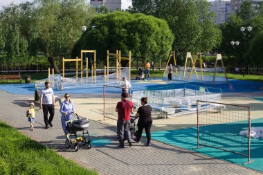 Moskova, Rusya - 7 Haziran 2020: Bebek arabalı yetişkinler ve çocuklar Bibirevo Park 'ta oyun parkının yakınında yürüyorlar. Moskova 'daki Covid-19 salgını nedeniyle oyun alanları kapalı..