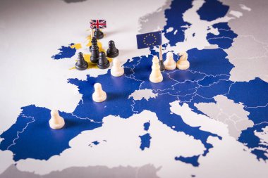 Satranç taşları ve bir Avrupa haritası üzerindeki bayraklar. Brexit kavramı Avrupa Birliği ve Amerika Birleşik Devletleri arasındaki pazarlıklar ve strateji.