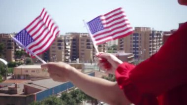 ABD ulusal bayrak el sallayarak ve vatansever ve Amerikan ulusal tatil 4ht Temmuz, bayrak günü, ulusal gün veya anma günü gibi kutlayan kırmızı giyimli kadın. Ağır çekim 120 fps özgün klipten
