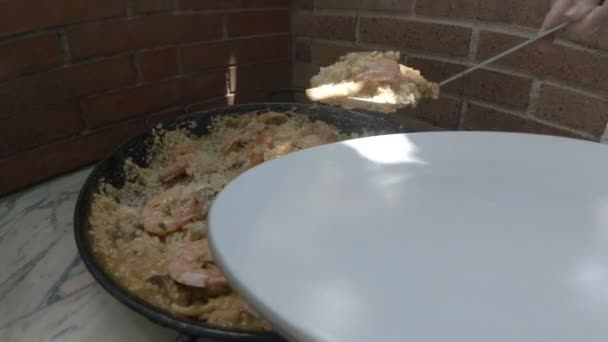 Servir verdadera paella tradicional española en un plato — Vídeos de Stock