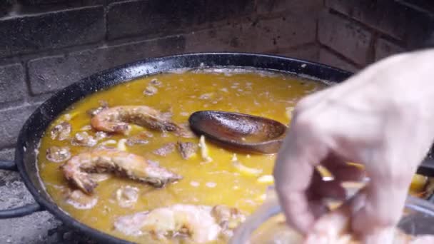 Koken van de Spaanse paella, het toevoegen van zeevruchten — Stockvideo